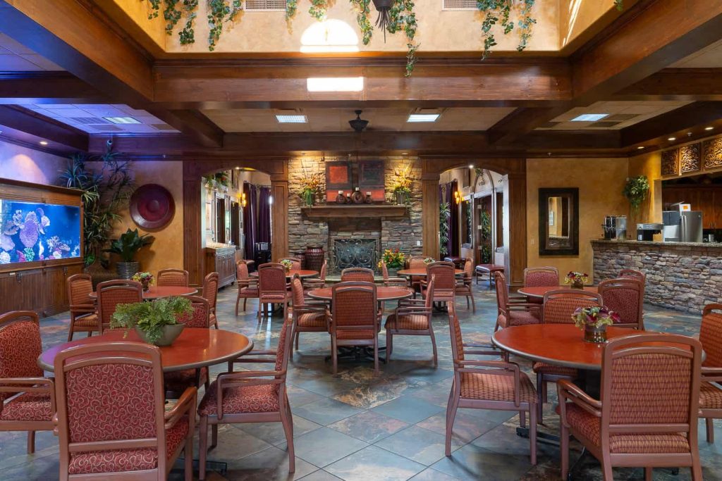 Carefree clubhouse dining room with a stone fireplace, aquarium and round dining tables