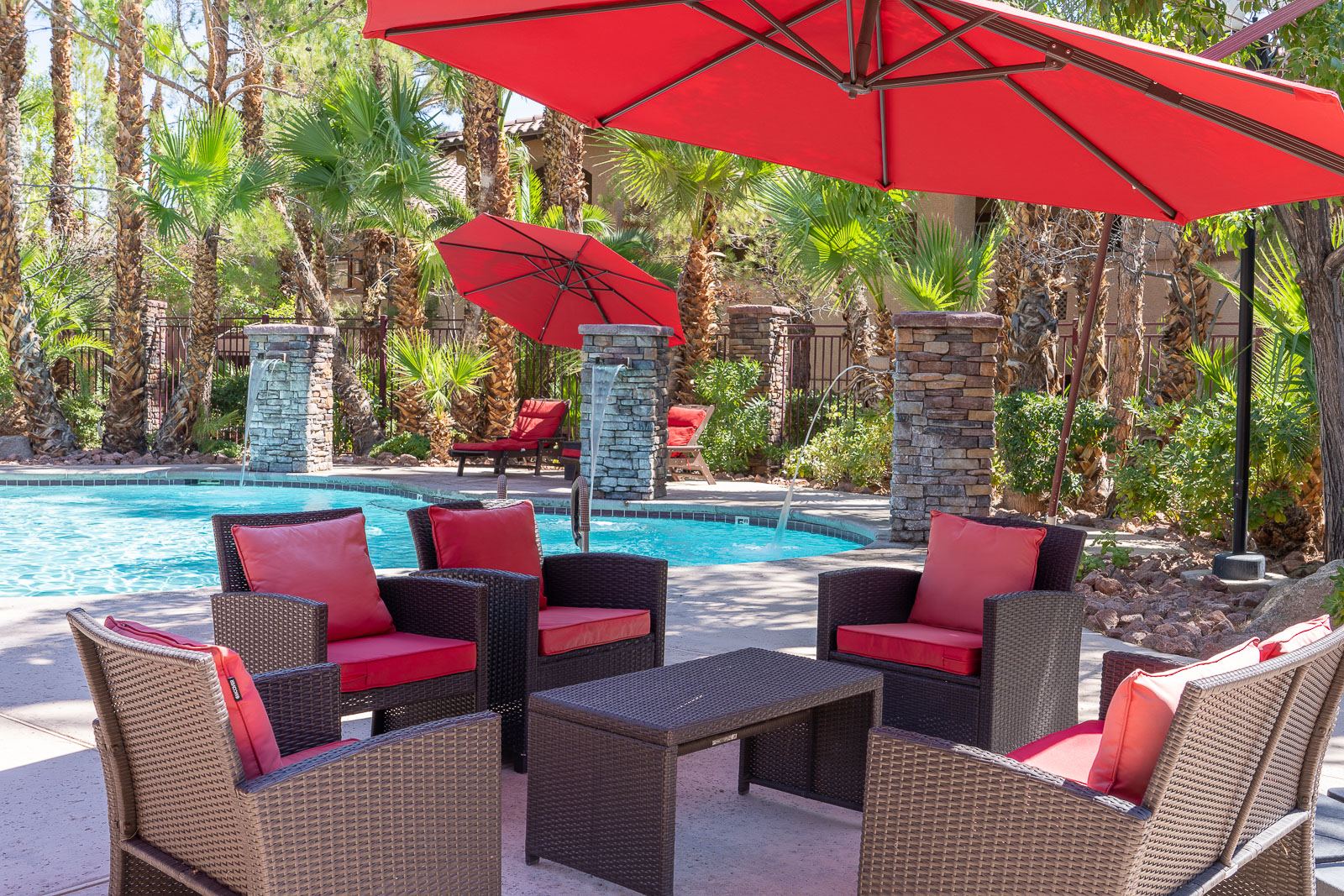 Poolside lounge seating under red umbrellas at The Willows in Las Vegas